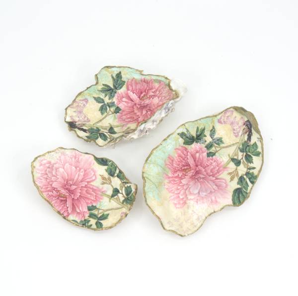 Set of three decoupaged oyster shells with painted gold trim, made by Salt Spring Island artist Cathie Grindler. 